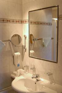 ein Bad mit einem Waschbecken und einem Spiegel in der Unterkunft Bärnthaler Gasthof Restaurant in Bad Sankt Leonhard im Lavanttal