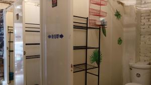 a bathroom with a toilet and a shelf at Matsu 1st Hostel in Nangan