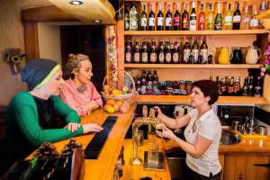 three women standing at a counter in a bar at Hotel Concordia in Podgórzyn