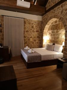 um quarto com uma cama e uma parede de tijolos em D'Argento Boutique Rooms in Ilha de Rhodes