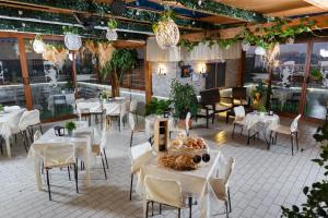 ein Restaurant mit weißen Tischen, Stühlen und Lampen in der Unterkunft Hotel Residence Confalone in Neapel