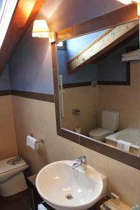 uma casa de banho com um lavatório, um WC e um espelho. em Hotel Convento Del Giraldo em Cuenca