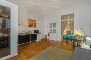 eine Küche und ein Wohnzimmer mit einem Tisch und Stühlen in der Unterkunft Chiado Balcony Apartment in Lissabon