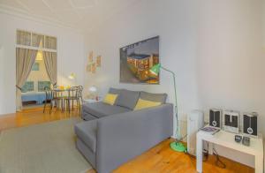 ein Wohnzimmer mit einem Sofa und einem Tisch in der Unterkunft Chiado Balcony Apartment in Lissabon