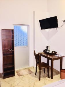 a room with a desk and a chair and a television at Ashford Beach in Matara