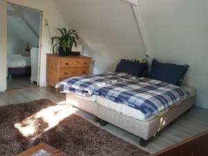 SchagerbrugにあるBuurtskap 't Buurtjeのベッドルーム1室(ベッド1台、植物付きドレッサー付)