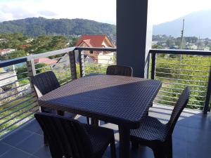 a table and chairs on a balcony with a view at Restful 3BR Hillside Duplex House in Baguio