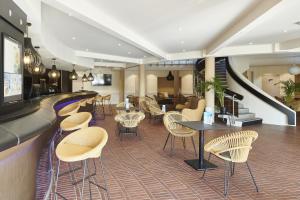 a restaurant with chairs and tables and a bar at Hôtel Vacances Bleues Delcloy in Saint-Jean-Cap-Ferrat