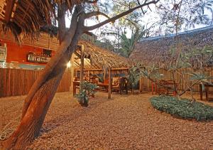 ein Restaurant mit einer Strohhütte mit einem Tisch und Stühlen in der Unterkunft Hotel Le Petit Paradis in Diego Suarez