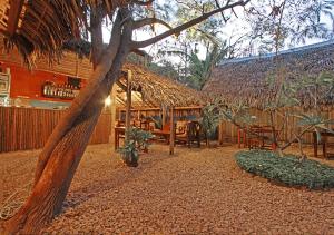 a restaurant with a straw hut with a table and chairs at Hotel Le Petit Paradis in Diego Suarez