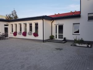 un edificio bianco con dei fiori sul lato di Arkadia Hostel a Mława