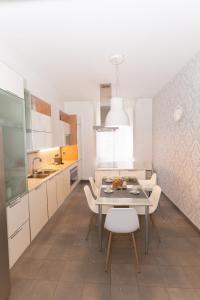 eine Küche mit einem Tisch und einigen weißen Schränken in der Unterkunft Luxury Laura Vatican Apartment ROMA CENTRO in Rom