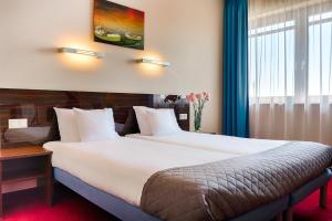 a hotel room with a large bed and a window at Focus Hotel Gdańsk in Gdańsk