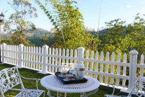 een wit hek met een tafel en stoelen in een tuin bij Hotel Mount Castle in Hatton