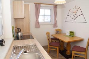 a kitchen with a sink and a wooden table at Haus Tauernseitn in Schladming