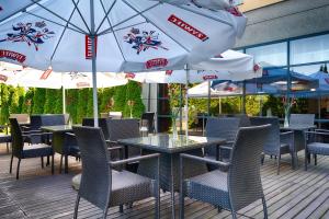 a patio with tables and chairs and umbrellas at Focus Hotel Gdańsk in Gdańsk