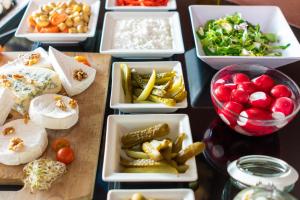 a table topped with bowls of different types of food at Focus Hotel Gdańsk in Gdańsk