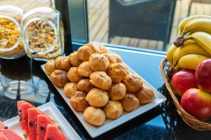 a plate of food on a table with fruit at Focus Hotel Gdańsk in Gdańsk