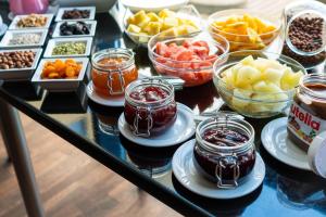 a table topped with bowls of fruit and desserts at Focus Hotel Gdańsk in Gdańsk