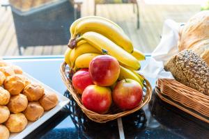 a basket of apples and bananas on a table with bread at Focus Hotel Gdańsk in Gdańsk