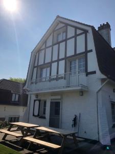 ein Haus mit einem Picknicktisch davor in der Unterkunft Villa Fernley in De Panne