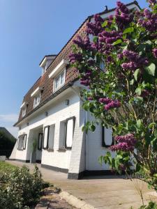 デ・パンネにあるVilla Fernleyの紫の花の白い家