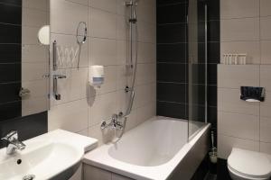 a bathroom with a tub and a sink and a toilet at Focus Hotel Gdańsk in Gdańsk