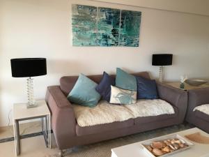 a living room with a brown couch with blue pillows at Seastar in Vilamoura