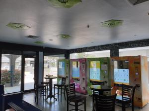 a dining room with tables and chairs and windows at Garden Inn, Penang in George Town