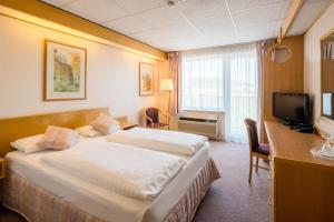 イェーナにあるベスト ウェスタン ホテル イェーナのベッド2台とテレビが備わるホテルルームです。
