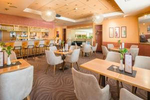 a restaurant with tables and chairs and a bar at Best Western Hotel Jena in Jena