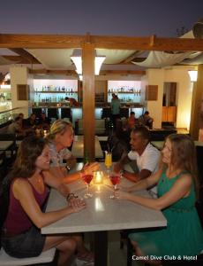 a group of people sitting at a table in a restaurant at Camel Dive Club & Hotel - Boutique Hotel in Sharm El Sheikh