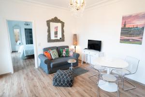 ein Wohnzimmer mit einem Sofa und einem Tisch in der Unterkunft Villa Golding - Flat 1 in Dresden