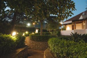 a garden at night with a stone wall and lights at Il Giardino di Venere in Mondello