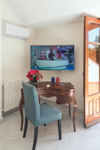 a desk with a blue chair and a table with a boat on the wall at Il Giardino di Venere in Mondello