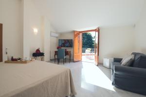 a living room with a bed and a couch and a table at Il Giardino di Venere in Mondello