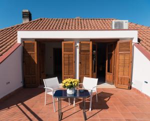 a patio with a table and chairs and a house at Il Giardino di Venere in Mondello