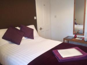 a bed with a tray on top of it with a mirror at Briscoe Lodge in Windermere