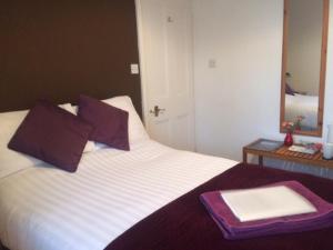 una cama con una bandeja encima con un espejo en Briscoe Lodge, en Windermere