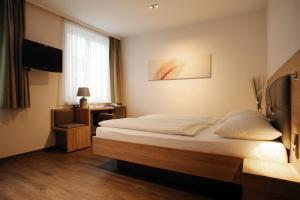 ザンクト・ペルテンにあるHotel-Gasthof Grafのベッドとテレビが備わるホテルルームです。