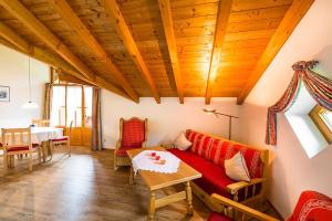 sala de estar con sofá rojo y mesa en Landhaus Kaufmann, en Bad Hindelang