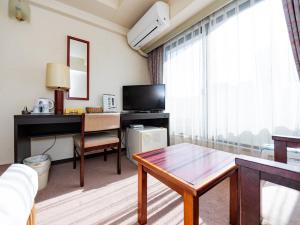 - un salon avec une table et un bureau dans l'établissement Sky Heart Hotel Koiwa, à Tokyo