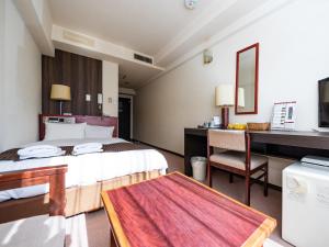 a hotel room with two beds and a desk at Sky Heart Hotel Koiwa in Tokyo