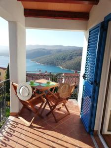 a patio with a table and chairs on a balcony at Apartments Mare Losinjska 16 in Rabac