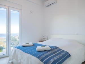 a white bedroom with a bed with towels on it at Villa Mariou in Plakias