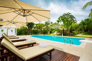 an image of a swimming pool with chairs and umbrellas at Villa Pimmada in Ao Nang Beach