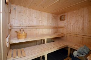 a wooden sauna with a bench in it at Hôtel Nakara by Odalys in Cap d'Agde