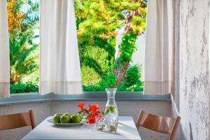 a table with a plate of fruit and a vase on it at Galaxy Villas in Hersonissos