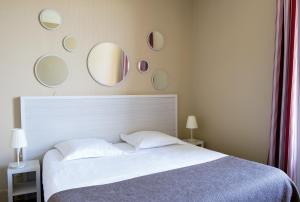 a bedroom with a bed with mirrors on the wall at Résidence de Tourisme Vacances Bleues Villa Regina in Arcachon