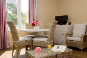 a living room with a table and chairs and a tv at Résidence de Tourisme Vacances Bleues Villa Regina in Arcachon